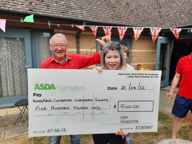 happy residents holding a check from Asda