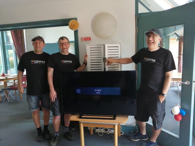 men repairing a television