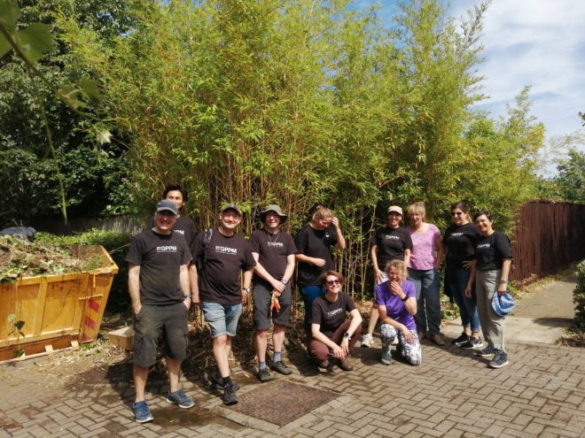 volunteers standing beside a skip